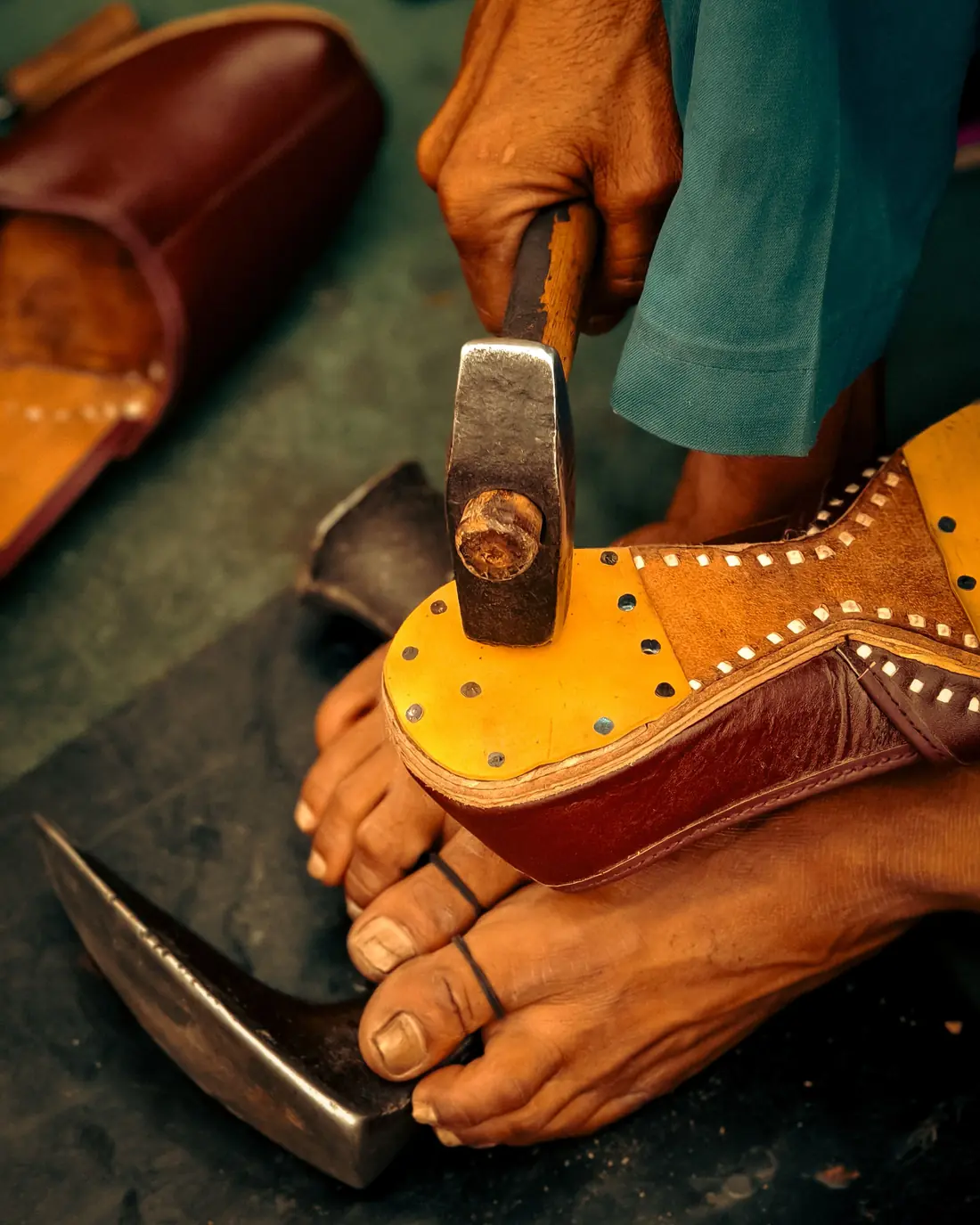 A karigar hammering a chappal sole by hand
