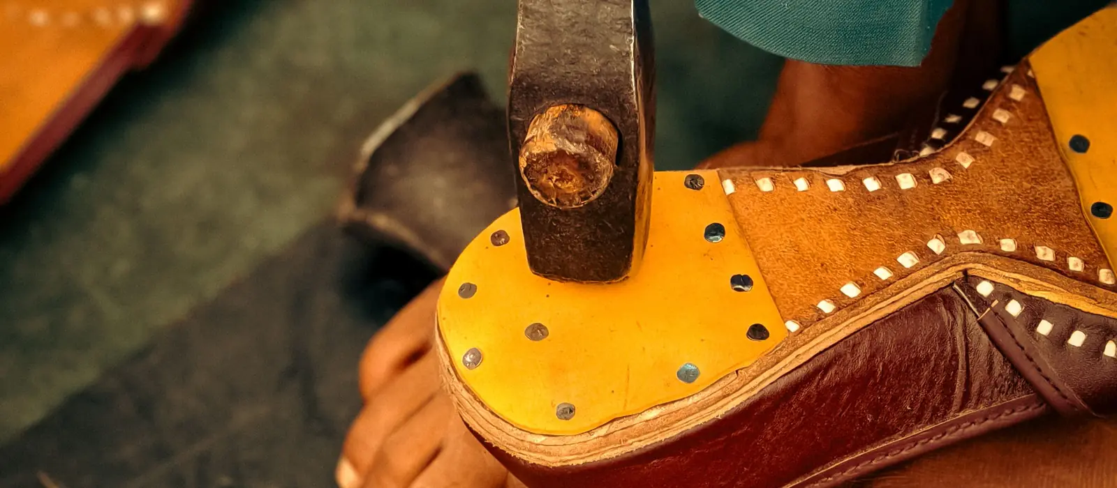 A karigar hammering a chappal sole by hand