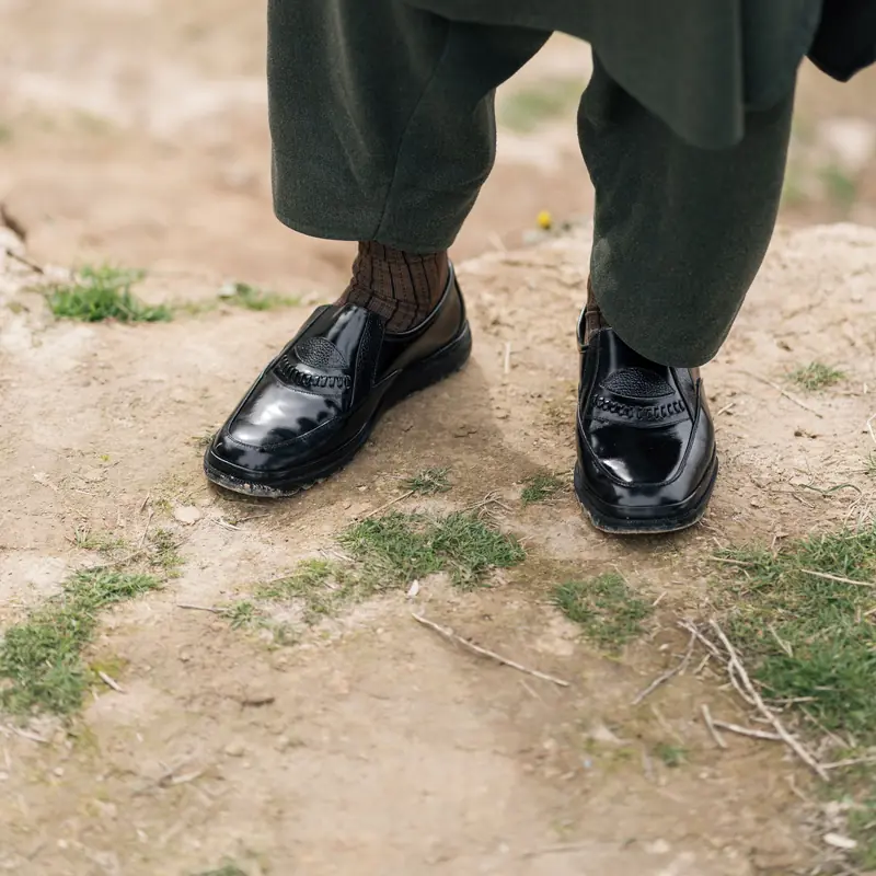 Polished black Peshawari chappals on dry earth