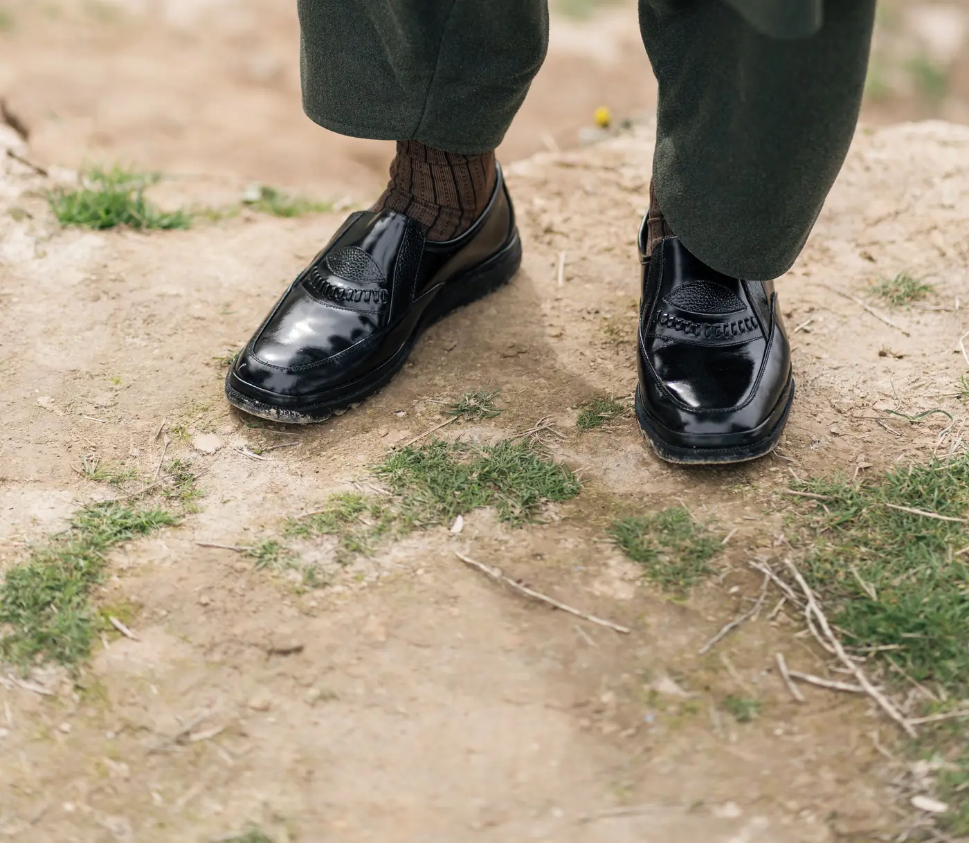 Polished black Peshawari chappals on dry earth